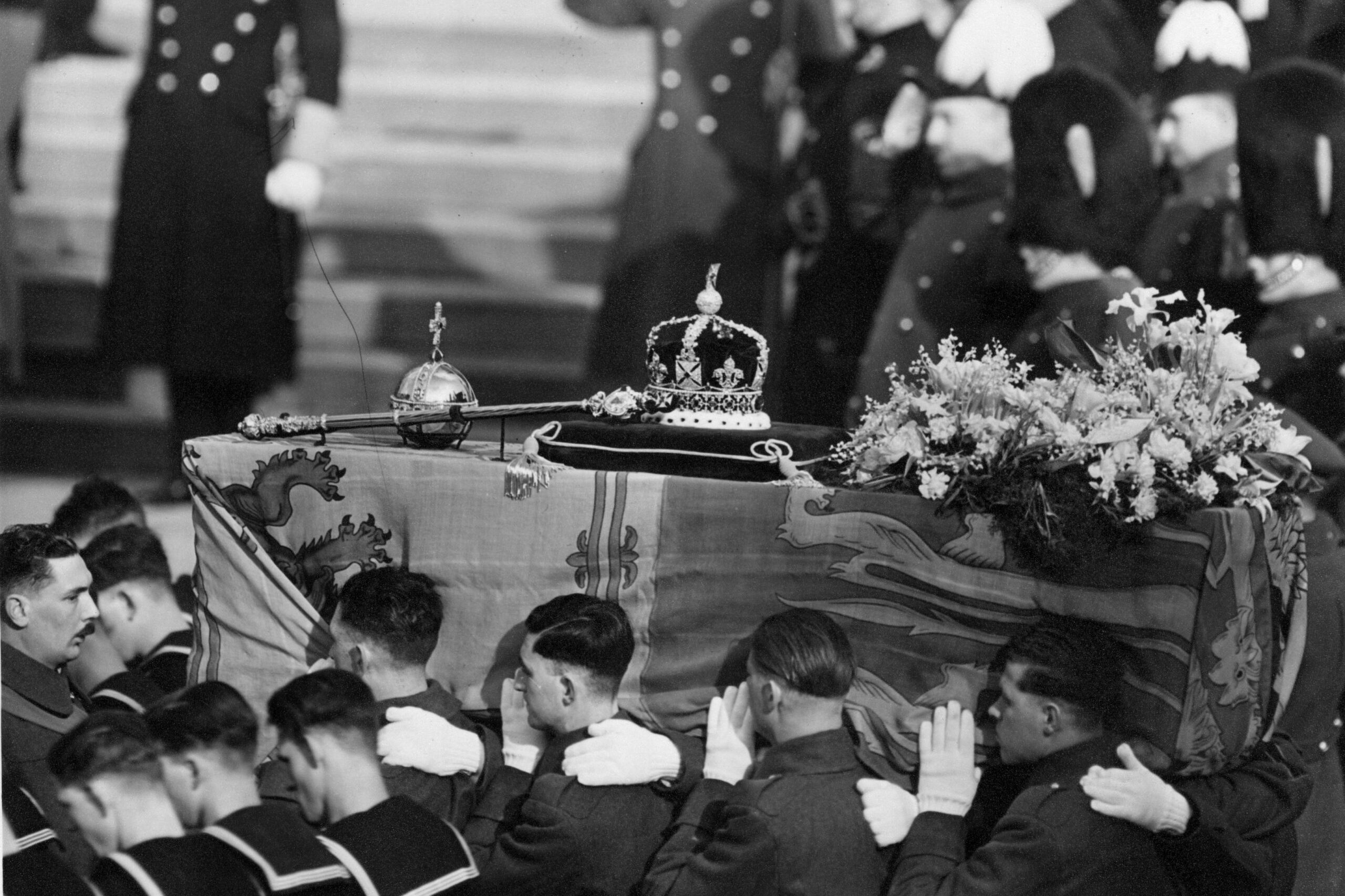 The coffin of George VI, draped with the royal standard being carried by soldiers at his funeral, 15th February 1952. On the top are symbols of royalty, a crown, sceptre and orb. (Photo by George W. Hales/Fox Photos/Hulton Archive/Getty Images)