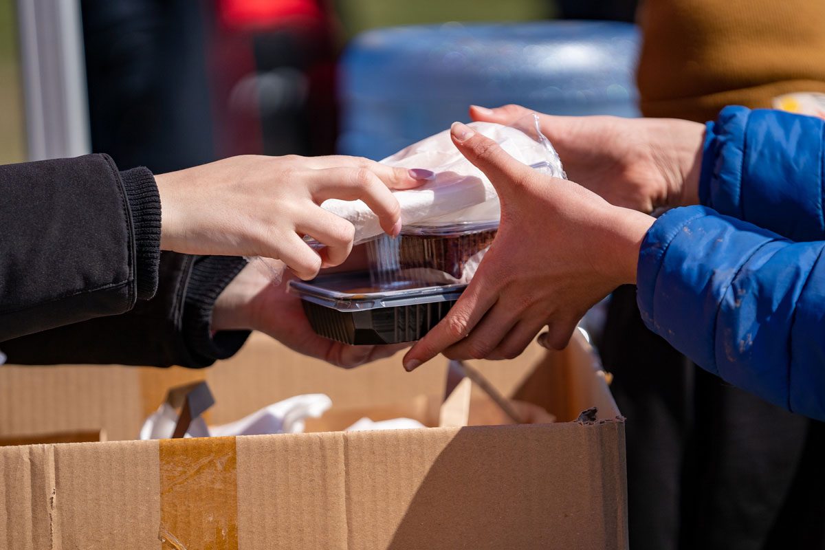 person handing food to another