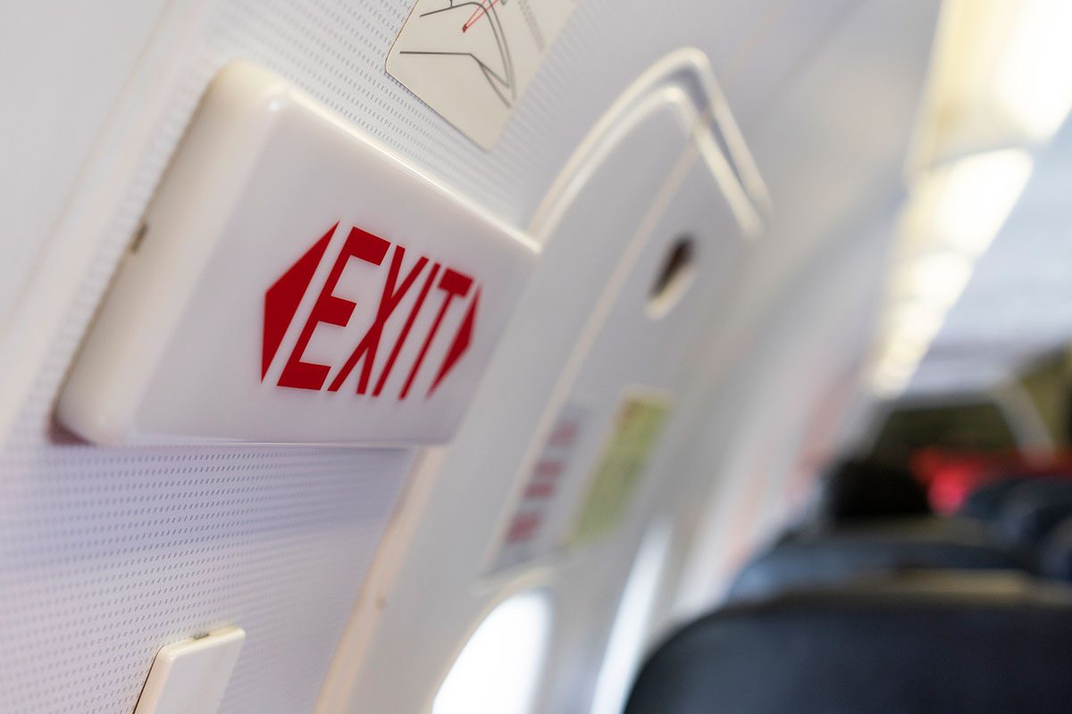 Close up shot sign in airplane near emergency exit doors