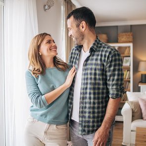 Portrait of a happy young couple smiling while standing together and looking at each other